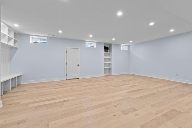 basement featuring baseboards, light wood-type flooring, and recessed lighting