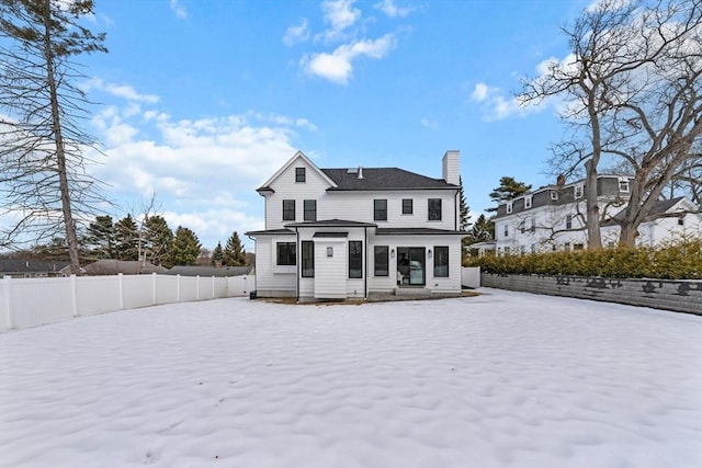 rear view of property featuring a fenced backyard and a chimney