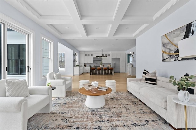 living room with beamed ceiling, coffered ceiling, and light wood-style floors