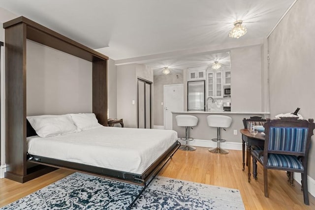 42 8th St Unit 4106, Boston, MA 02129 - bedroom featuring built in fridge, light wood-style flooring, a sink, and baseboards