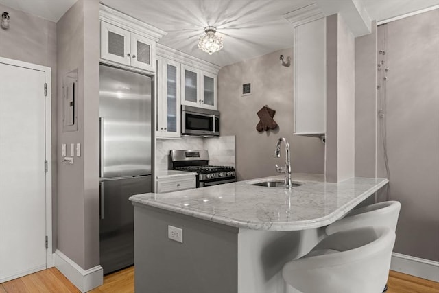 42 8th St Unit 4106, Boston, MA 02129 - kitchen featuring stainless steel appliances, a sink, a peninsula, and light wood-type flooring