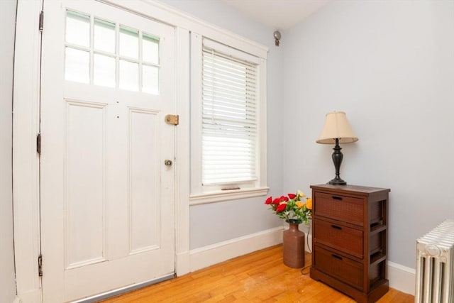 entryway featuring radiator, light wood-type flooring, and baseboards