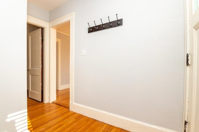 corridor with baseboards and wood finished floors