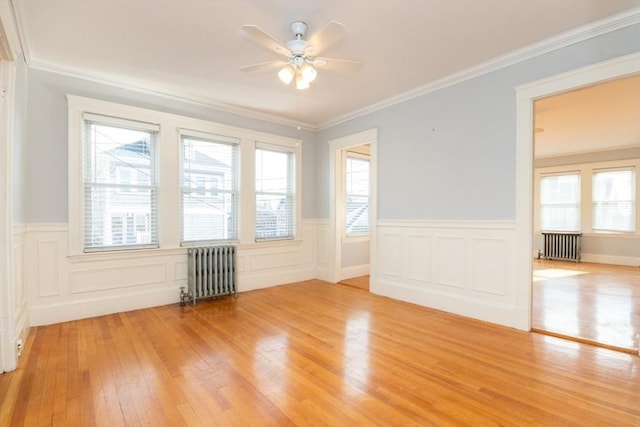 unfurnished room featuring radiator heating unit, crown molding, a ceiling fan, and wood finished floors