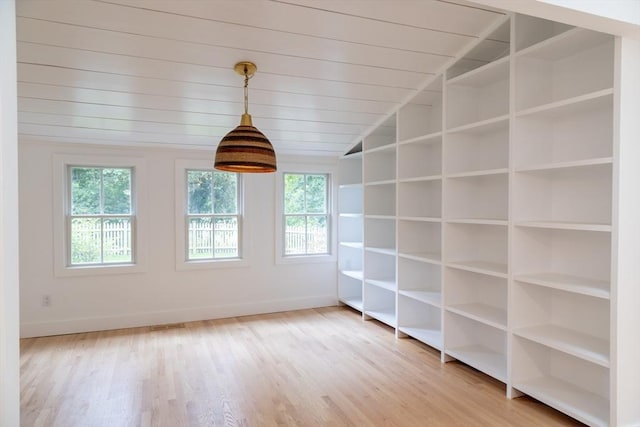 empty room with wood ceiling, a healthy amount of sunlight, lofted ceiling, and wood-type flooring