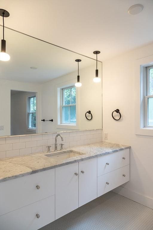 bathroom featuring vanity and backsplash