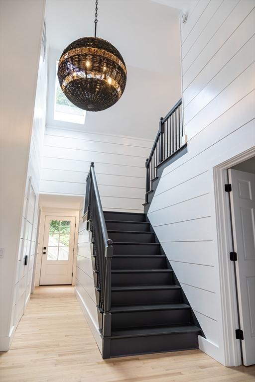 staircase with wood-type flooring and a high ceiling