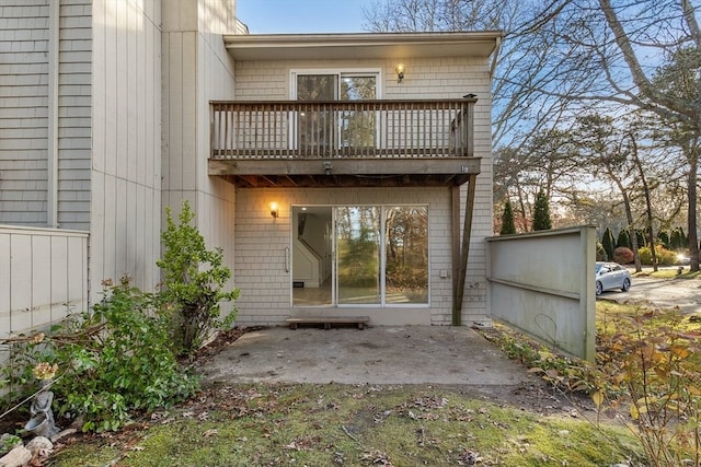 rear view of house featuring a patio and a balcony