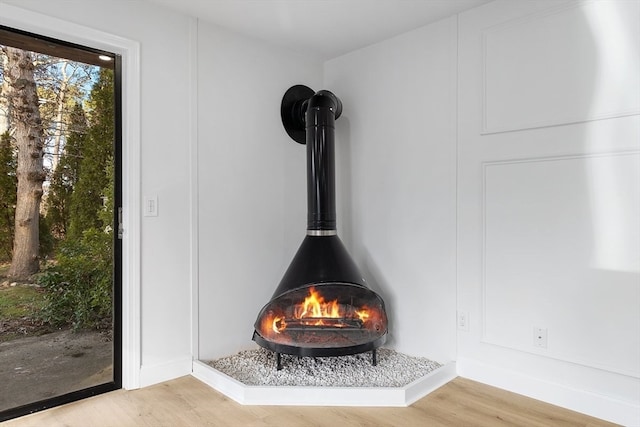 interior details with a wood stove and hardwood / wood-style flooring