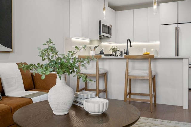 100 Lincoln St Unit 303, Boston, MA 02135 - kitchen featuring a breakfast bar, pendant lighting, light countertops, and white cabinets