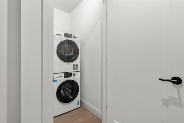 100 Lincoln St Unit 303, Boston, MA 02135 - laundry area with stacked washer / dryer and wood finished floors