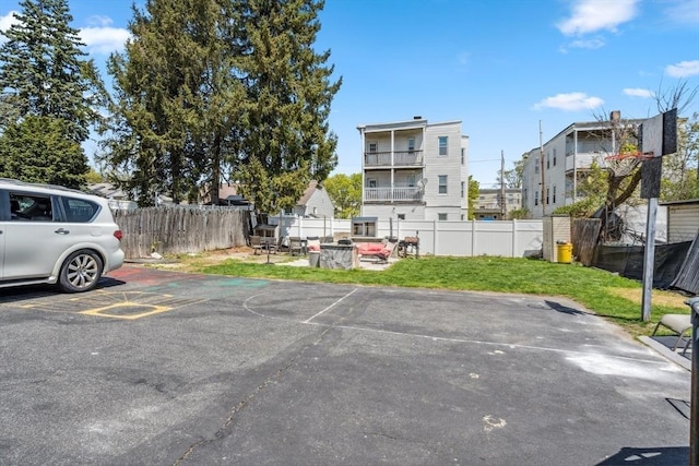 uncovered parking lot featuring fence