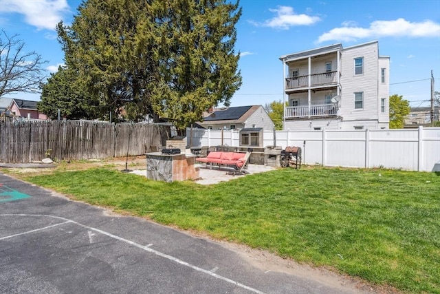 view of yard with a fenced backyard, an outdoor living space with a fire pit, and a patio area