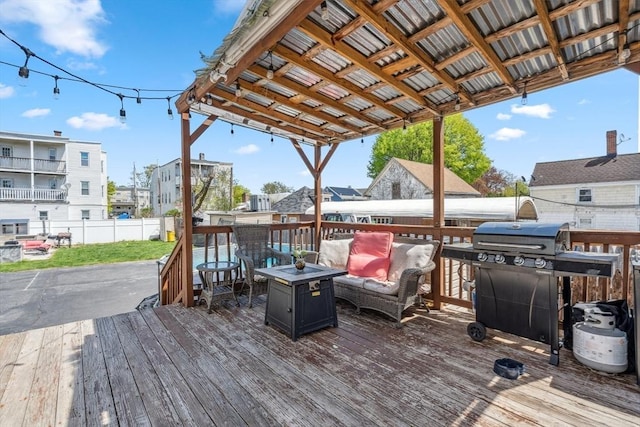 deck with fence, an outdoor living space with a fire pit, and grilling area
