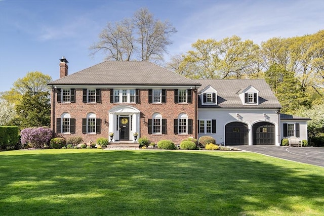 115 Rutledge, Belmont, MA 02478 - colonial house with a chimney, a front yard, a garage, asphalt driveway, and brick siding