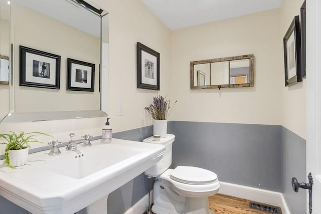 115 Rutledge, Belmont, MA 02478 - half bathroom with toilet, wood finished floors, a sink, and baseboards