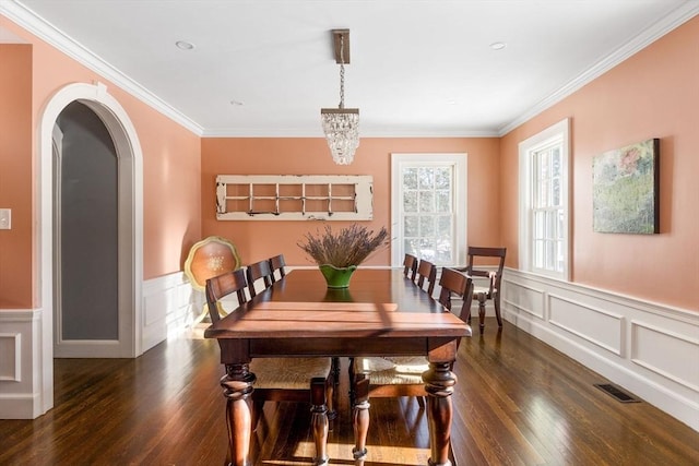 115 Rutledge, Belmont, MA 02478 - dining space featuring dark wood-type flooring, ornamental molding, a wainscoted wall, arched walkways, and a decorative wall