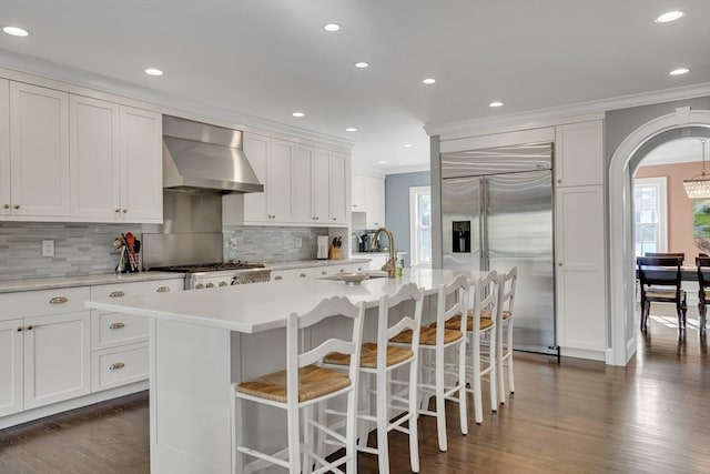 115 Rutledge, Belmont, MA 02478 - kitchen featuring wall chimney exhaust hood, appliances with stainless steel finishes, crown molding, dark wood finished floors, and light countertops
