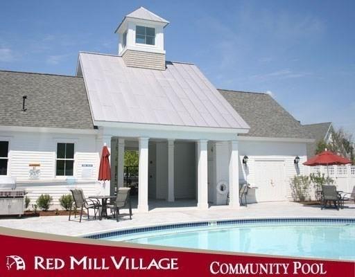 back of property featuring a community pool, a patio area, and roof with shingles