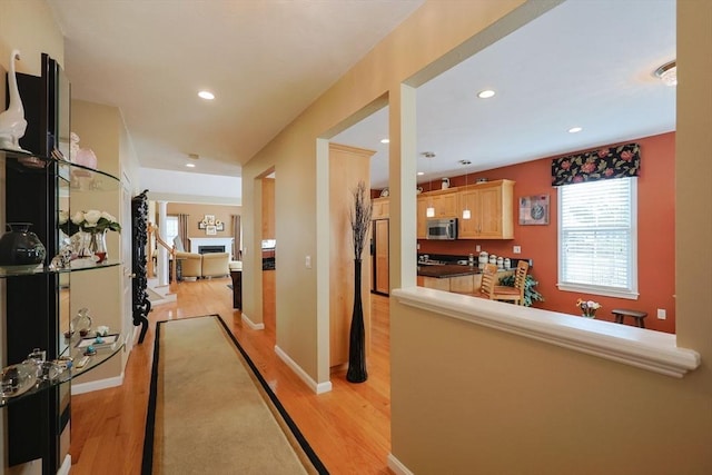hallway with light wood-style floors, recessed lighting, and baseboards