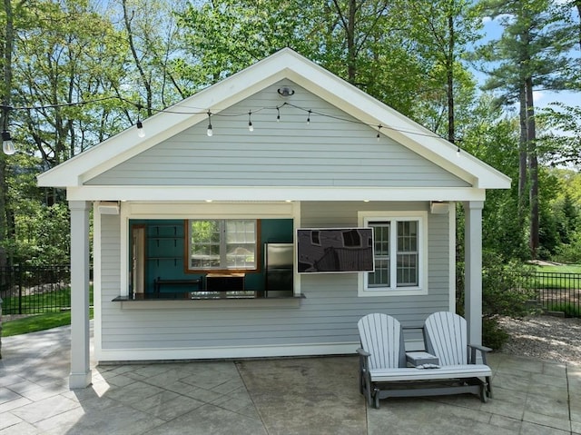 view of front of home with fence and a patio area