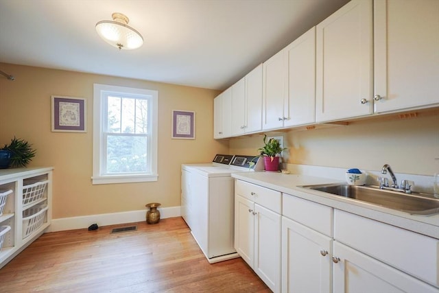 185 Read St, Seekonk, MA 02771 - laundry area with separate washer and dryer, cabinet space, baseboards, and light wood-style flooring