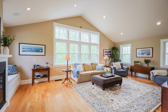 185 Read St, Seekonk, MA 02771 - living room with vaulted ceiling, a glass covered fireplace, light wood-style floors, baseboards, and recessed lighting