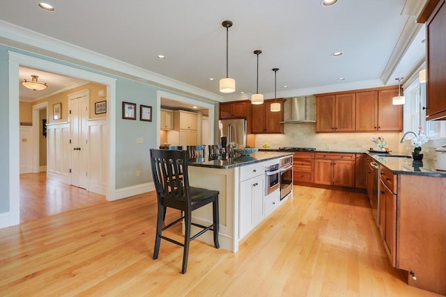 185 Read St, Seekonk, MA 02771 - kitchen with wall chimney exhaust hood, appliances with stainless steel finishes, light wood-style floors, a breakfast bar, and ornamental molding