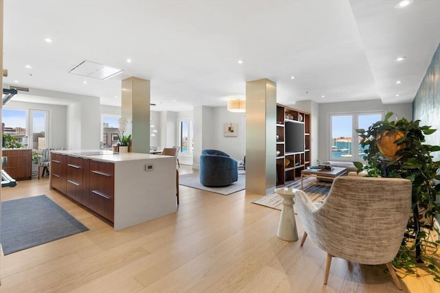 kitchen featuring modern cabinets, open floor plan, a large island with sink, light wood-style flooring, and recessed lighting