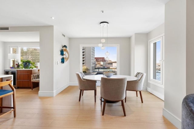 dining room with light wood-style floors, baseboards, and recessed lighting