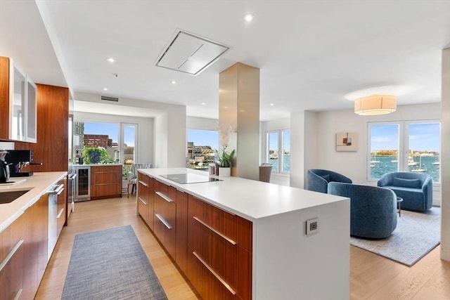 kitchen with modern cabinets, a large island, light wood finished floors, light countertops, and recessed lighting