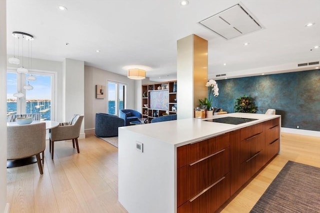 kitchen featuring modern cabinets, black electric cooktop, open floor plan, light wood-style flooring, and recessed lighting