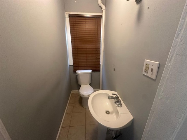 bathroom featuring tile patterned flooring, a sink, baseboards, and toilet