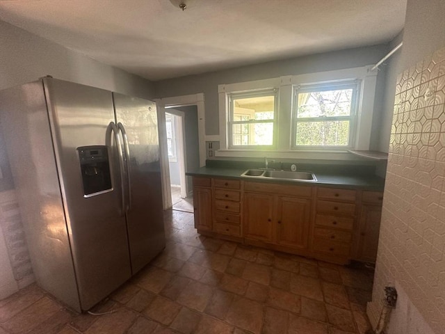 kitchen featuring stainless steel refrigerator with ice dispenser, a sink, and light brown cabinets