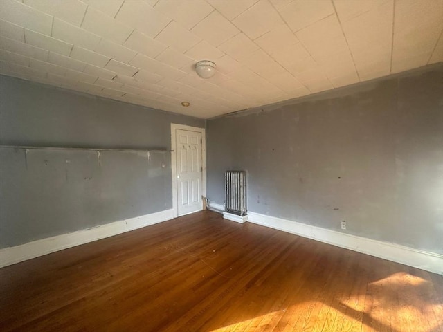 unfurnished room with wood finished floors and baseboards