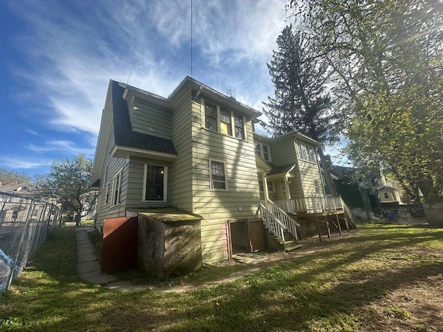 view of side of property with fence, a wooden deck, and stairway
