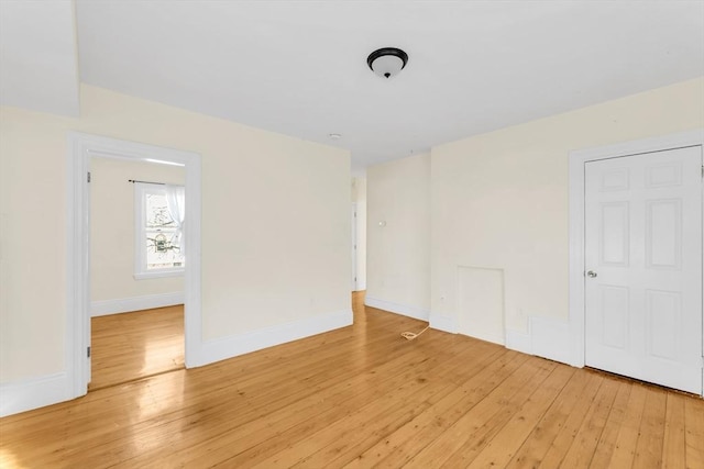 unfurnished room with light wood finished floors and baseboards