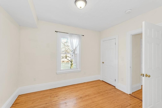 unfurnished room with light wood-style flooring and baseboards