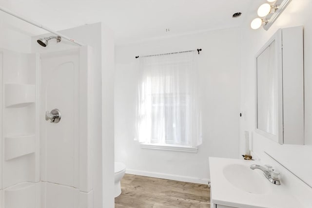 bathroom with walk in shower, baseboards, toilet, vanity, and wood finished floors