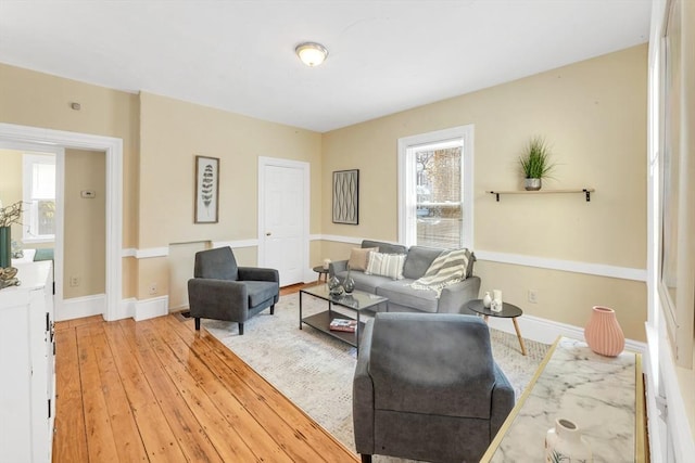 living area featuring light wood-style floors and baseboards
