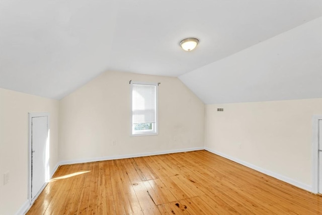 additional living space featuring light wood-type flooring, baseboards, and lofted ceiling