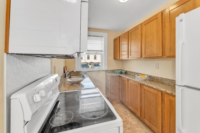 kitchen with brown cabinets, light tile patterned floors, a sink, and white appliances