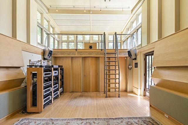 44 Ripley Hill Rd, Concord, MA 01742 - bar area with hardwood / wood-style floors, a towering ceiling, stairs, and track lighting