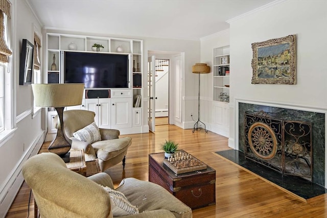44 Ripley Hill Rd, Concord, MA 01742 - living area featuring built in features, baseboard heating, crown molding, wood finished floors, and a fireplace