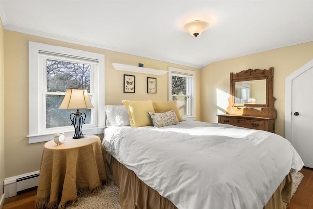 bedroom with dark hardwood / wood-style flooring and a baseboard heating unit