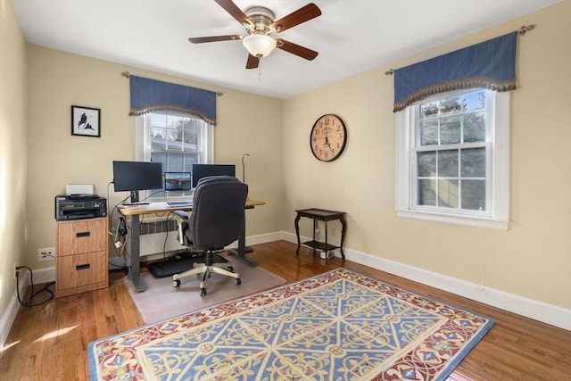 home office with hardwood / wood-style flooring, radiator, and ceiling fan