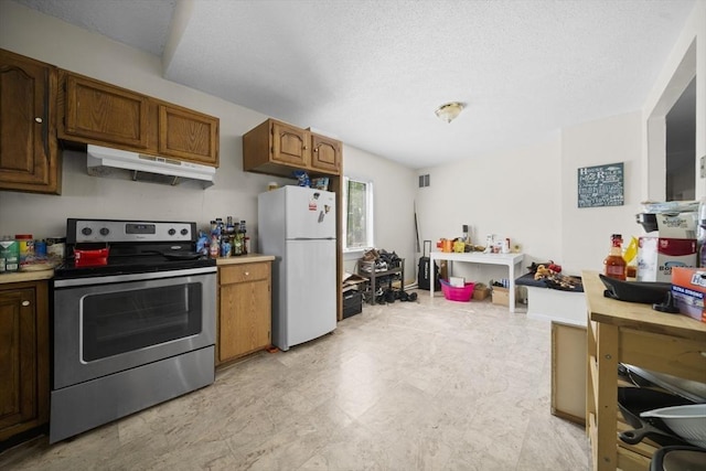 kitchen with electric stove, freestanding refrigerator, under cabinet range hood, light countertops, and a textured ceiling