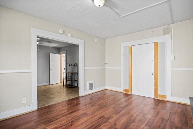 spare room with wood finished floors, baseboards, and a ceiling fan