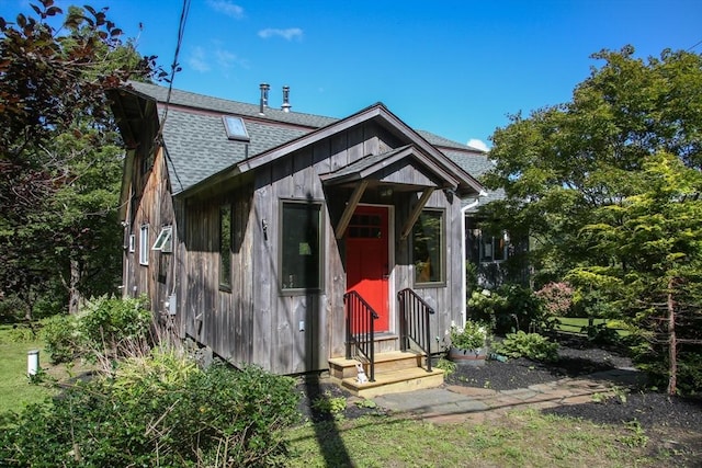 view of front facade with a shingled roof and entry steps