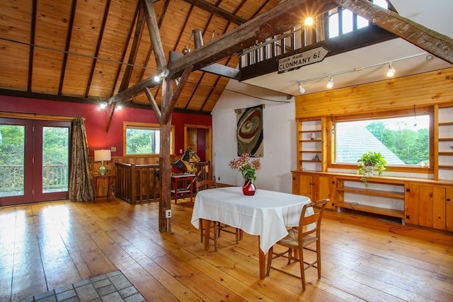 dining space featuring high vaulted ceiling, light wood-style floors, wood ceiling, and beam ceiling